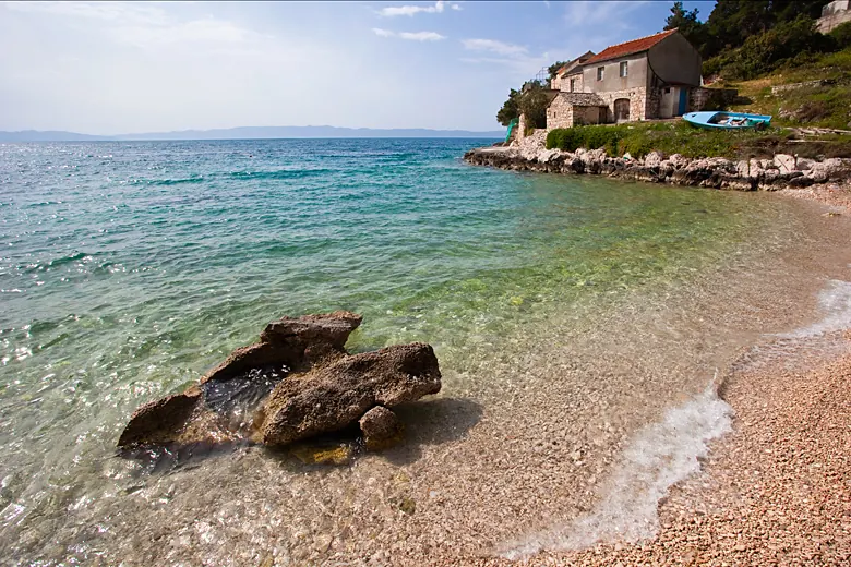 Plaža u dnu uvale — šljunak, pijesak i plitko.